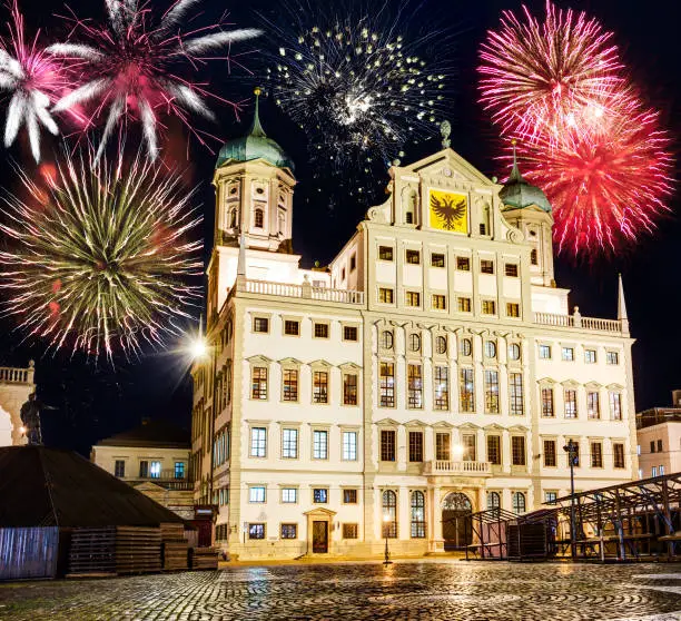 Fireworks at the illuminated town hall of Augsburg (Germany) at night.