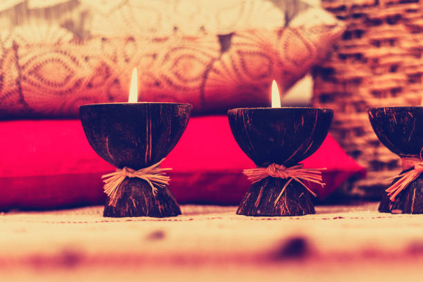 istock Burning spa aroma candles in coconut shell, pillows and plaid, cozy home interior background. 1093246362