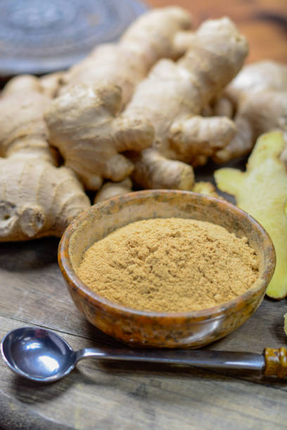 istock Fresh raw ginger root and bowl with ginger powder close up 1093247872