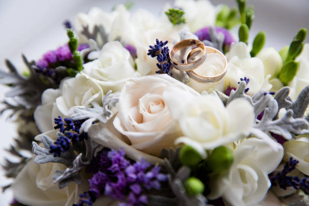 hochzeit goldene ringe auf einem bouquet von blumen - cluster verlobungsringe stock-fotos und bilder