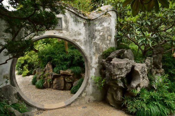 Part of a tourist walkway in the Humble Administrator's Garden with a circular portal through a garden wall
