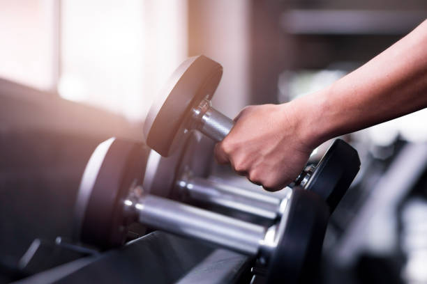 istock Dumbbells on rack, with different weight, macro shoot and very detailed on lifting handle, Standard equipment in all gym. 1093262610