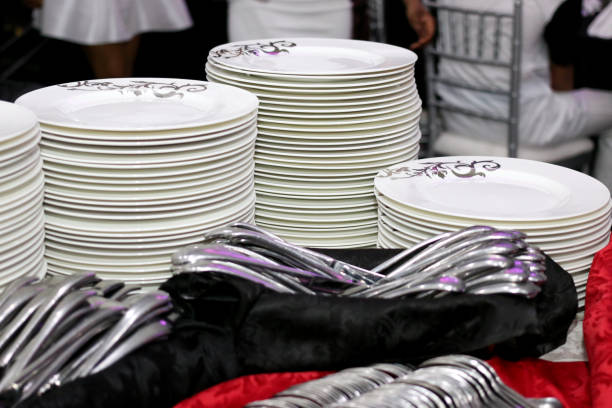 stacks of clean white plates and utensils at a restaurant