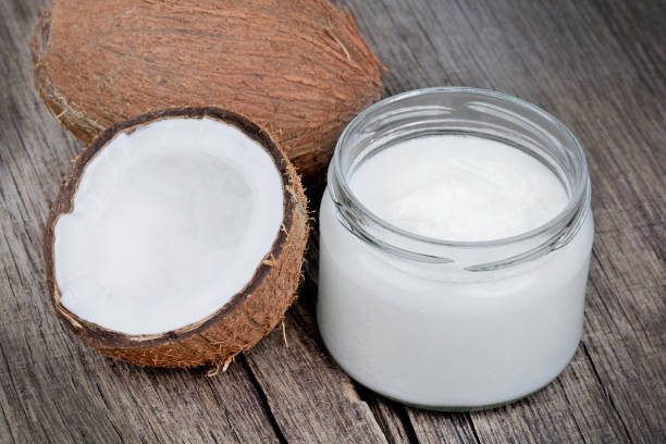 istock Coconut oil and fresh coconuts on old table 1093281504