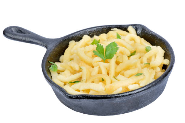 Pan with spatzle with butter and parsley on white background stock photo