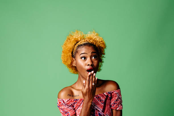 istock Young woman with a shocked expression looking at something, isolated on green studio background 1093290276