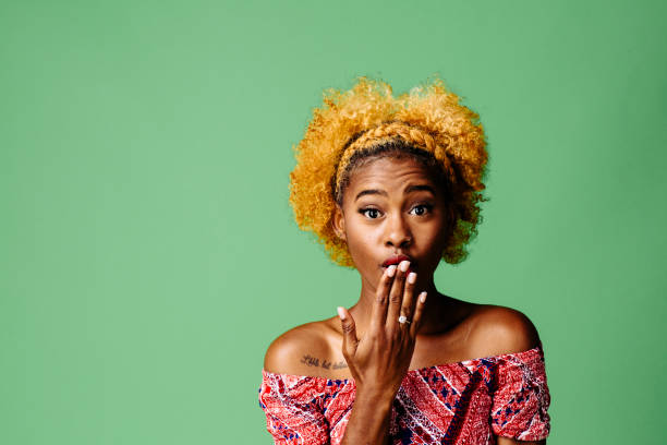 istock Young woman with a shocked expression looking at the camera, isolated on green studio background 1093290280