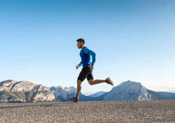 desportista correndo na estrada de asfalto - running jogging road exercising - fotografias e filmes do acervo