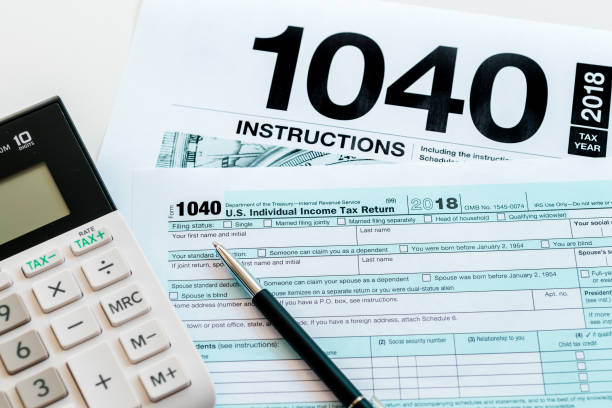istock New 2019 IRS 1040 tax form, instructions, pen and calculator 1093295174