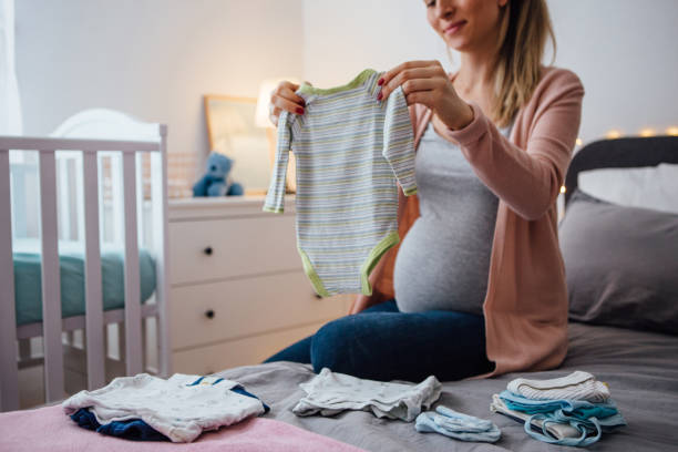 istock Future mom holds baby clothing 1093295290