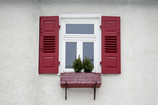 Old ancient wooden window with blinds or shutters. Scenic original and colorful view of antique windows in old city Sindelfingen, Germany. Isolated on wall. No people. Front view. Old fashioned style.