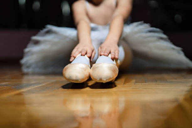 スタジオ撮影屋内、木製の床に座っているトウシューズのバレリーナ。 - ballet dress studio shot costume ストックフォトと画像