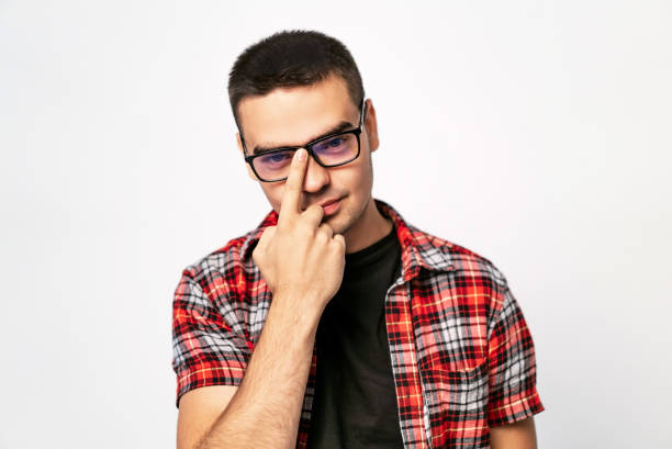 istock Young man adjusting the glasses he wears with a smile isolated on a white background. 1093312480