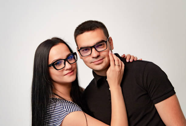 istock Lovely smiling couple wearing spectacles looking at camera over the white background 1093313034