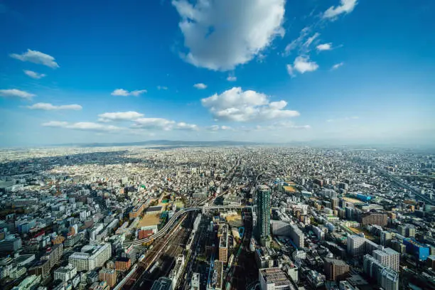 Aerial ultra-ultra wide angle view of the vast nearly endless Osaka Cityscape towards the horizon in warm late afternoon light. Osaka, Honshu, Japan, Asia.