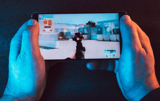 istock Hand holds on to smart phone while playing an action video game 1093332050