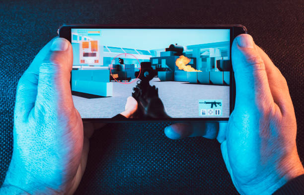 istock Man holds on to his smart phone as he plays a video game 1093332072