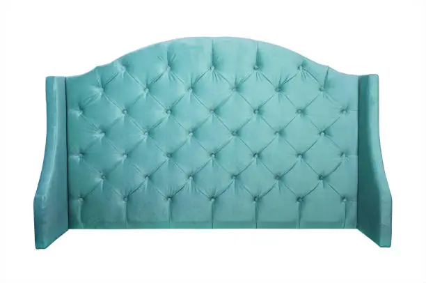 Shaped pastel teal blue color soft velvet fabric capitone bed headboard of Chesterfiels style sofa isolated on white background, front view