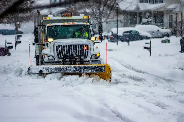 Heavy equipment driver working to push snow to the side of the streets after a blizzard