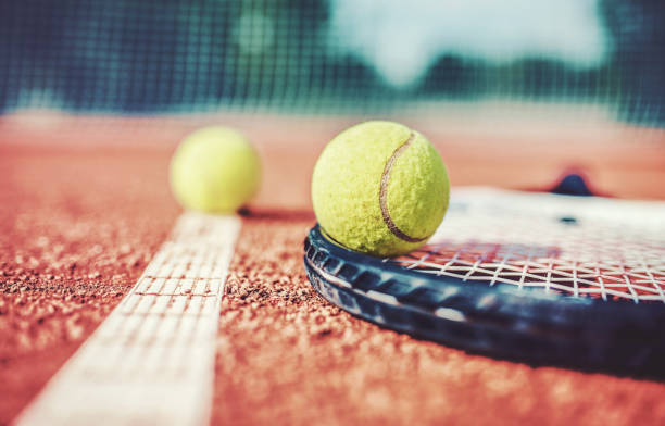 pelota de tenis con la raqueta en la cancha de tenis. deporte, concepto de recreación - tennis court tennis ball racket fotografías e imágenes de stock