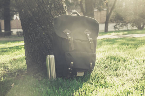 istock Vintage backpack with thermos stands on the grass under a tree, retro style toned 1093346716
