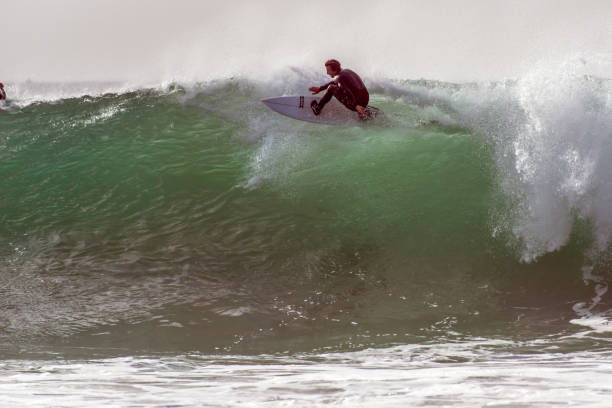 Big wave surfing on a winters day at North Shore, Oahu, Hawaii. This ist the so called Banzai Pipeline. A surfer is crashing in to the waves and flies above the scenery.