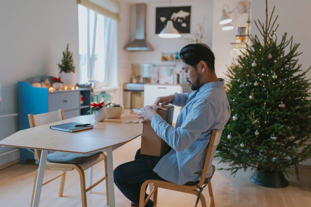 istock Single Japanese man opens received parcel during Christmas 1093352822