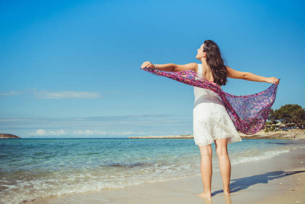 istock Woman spreading arms at the beach 1093364744