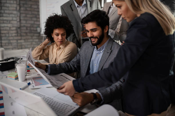 istock Group of multi ethnic architects cooperating while examining blueprints on a meeting in the office 1093365346