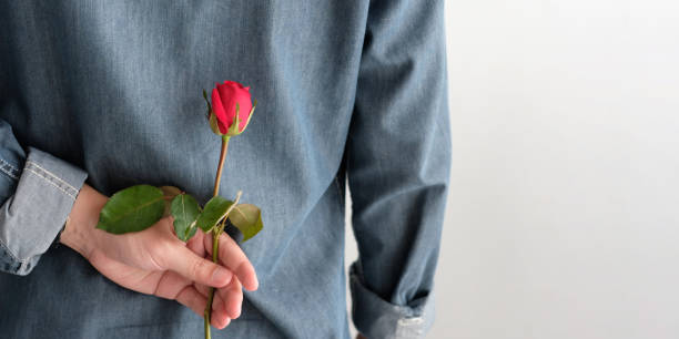istock Valentine's day concept, Back side of man holding red rose on white background with copy space 1093376854