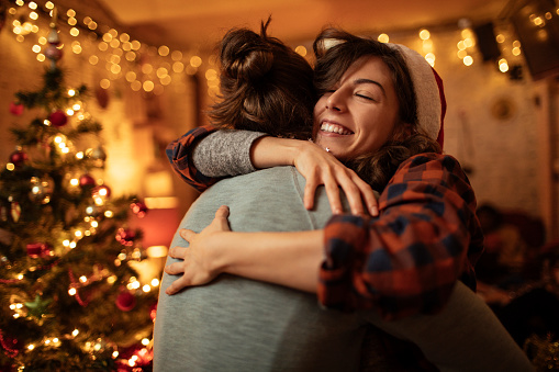 Boy and girl hugging by the Christmas tree