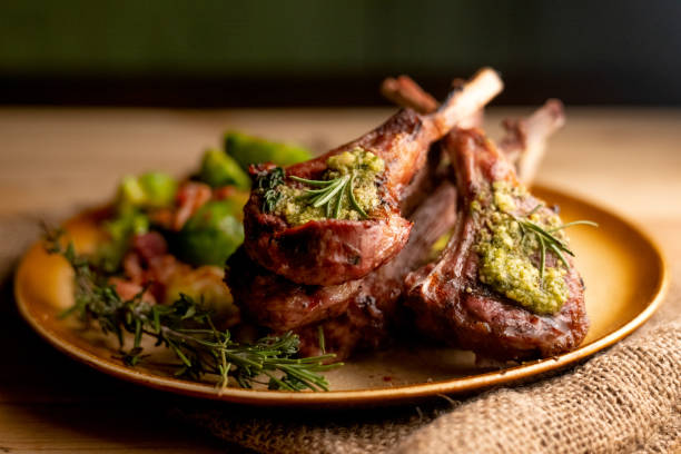 grilled new zealand lamb chops plated with sauteed brussel sprouts - carneiro imagens e fotografias de stock