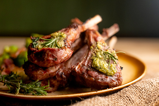 Charcoal grilled rack of lamb chops topped with pesto and rosemary and sauteed Brussel sprouts with bacon and onion p