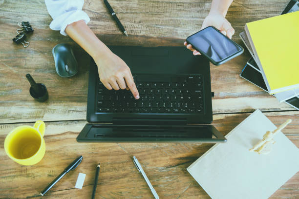 istock woman young working with a smartphone while working with a laptop in the holiday. 1093396668