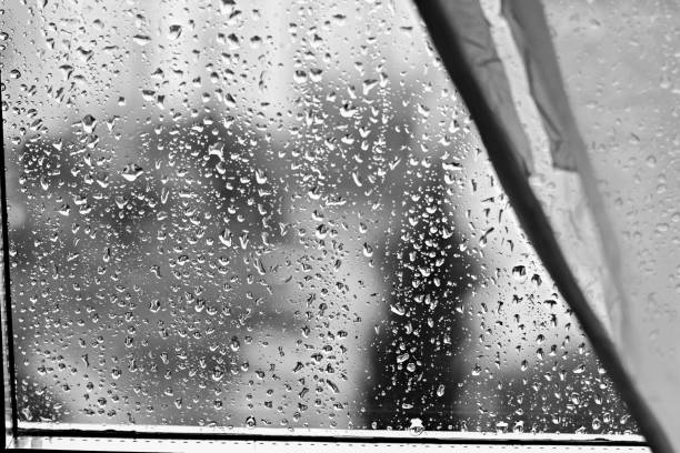 istock Rain drops on window glass background at rainy day blurred outside sky cloud blue texture 1093461010