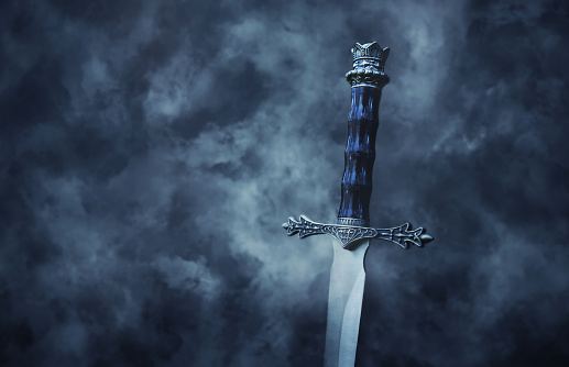 mysteriousand foto mágico de espada de plata sobre fondo negro Nevado gótico. Concepto de época medieval. photo