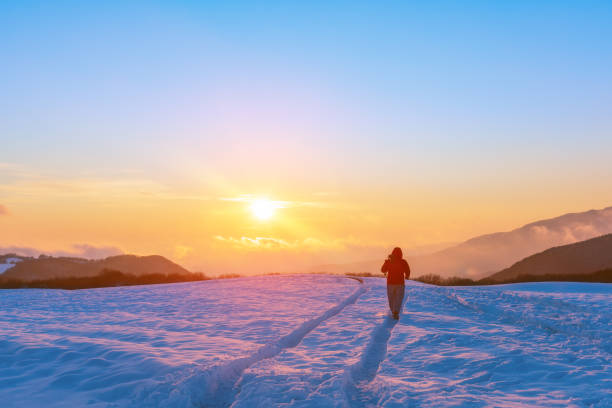 istock Nature photographer on a snowy field at sunset time 1093463108