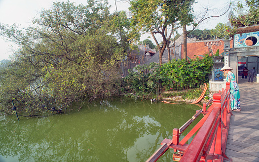 Hanoi, Vietnam - December 25,2018 : Unidentified foreigner lady looking on the Beautiful view of the Huc Bridge leads to Ngoc Son Temple on a small island, Hoan Kiem Lake, Hanoi, Vietnam