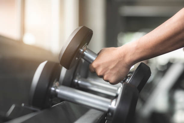 istock Dumbbells on rack, with different weight, macro shoot and very detailed on lifting handle, Standard equipment in all gym. 1093487172