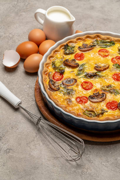 istock Baked homemade quiche pie in ceramic baking form, eggs and cream 1093487422