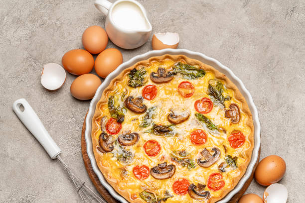 istock Baked homemade quiche pie in ceramic baking form, eggs and cream 1093487434
