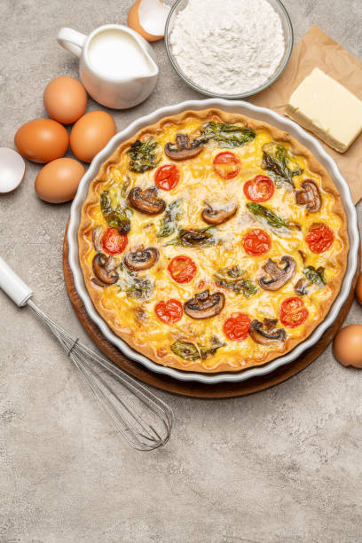 istock Baked homemade quiche pie in ceramic baking form, eggs and cream 1093487436