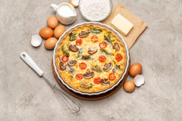 istock Baked homemade quiche pie in ceramic baking form, eggs and cream 1093487454