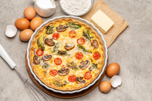 istock Baked homemade quiche pie in ceramic baking form, eggs and cream 1093487462