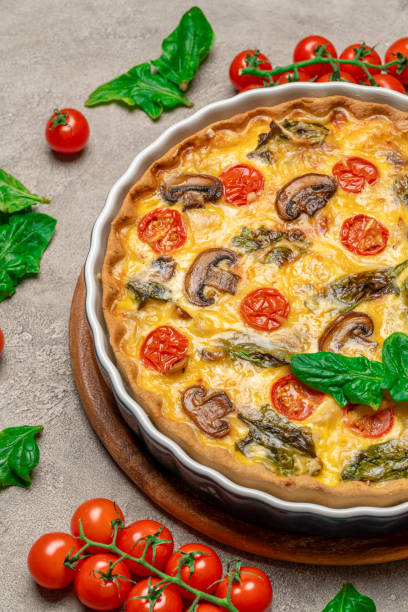 istock Baked homemade quiche pie in ceramic baking form on concrete background 1093487584