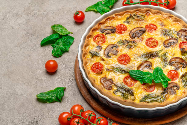 istock Baked homemade quiche pie in ceramic baking form on concrete background 1093487590