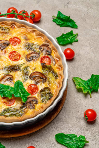 istock Baked homemade quiche pie in ceramic baking form on concrete background 1093487594