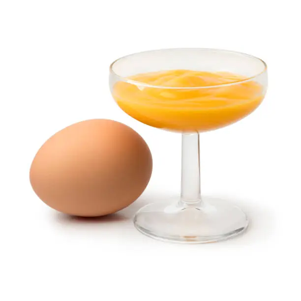 Glass with traditional dutch egg liqueur, called advokaat, and an egg isolated on white background