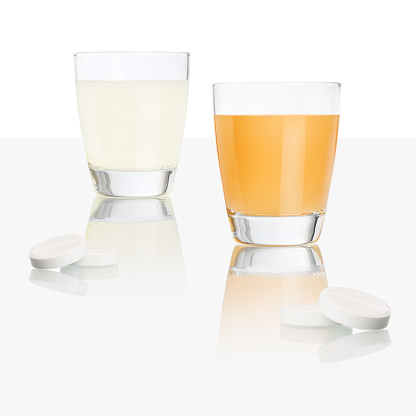 tabletas de aspirina y vidrio aislado en mesa blanca, naranja y limón vitamina c, frío y gripe curan concepto photo