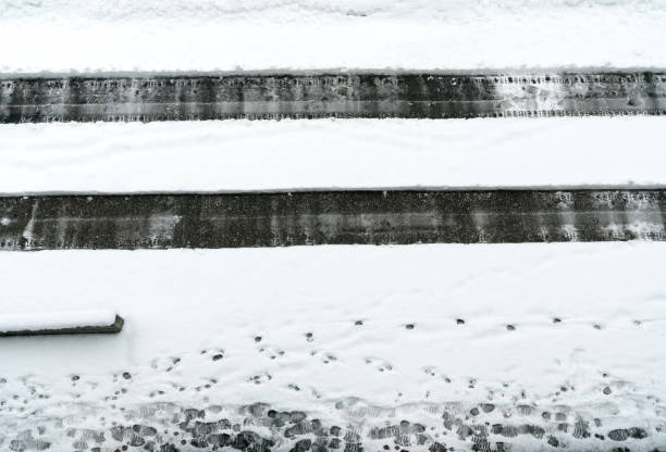 cleared path through deep snow on an asphalt road after a heavy snowfall